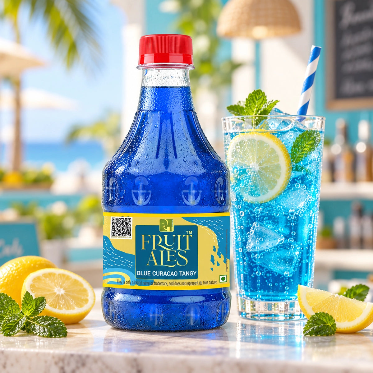 A bottle of Fruit Ates Blue Curacao Tangy syrup stands on a countertop beside a tall glass of blue iced drink with lemon slices, mint, and a striped straw. The background is a blurred tropical beach and bar setting.
