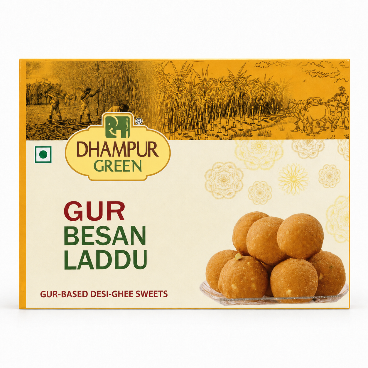 A box of Dhampur Green Gur Besan Laddu on a plain white background. The packaging features a golden-yellow top section with traditional illustrations, a cream-colored lower section with floral patterns, and a photo of golden-brown laddu sweets on the bottom right.