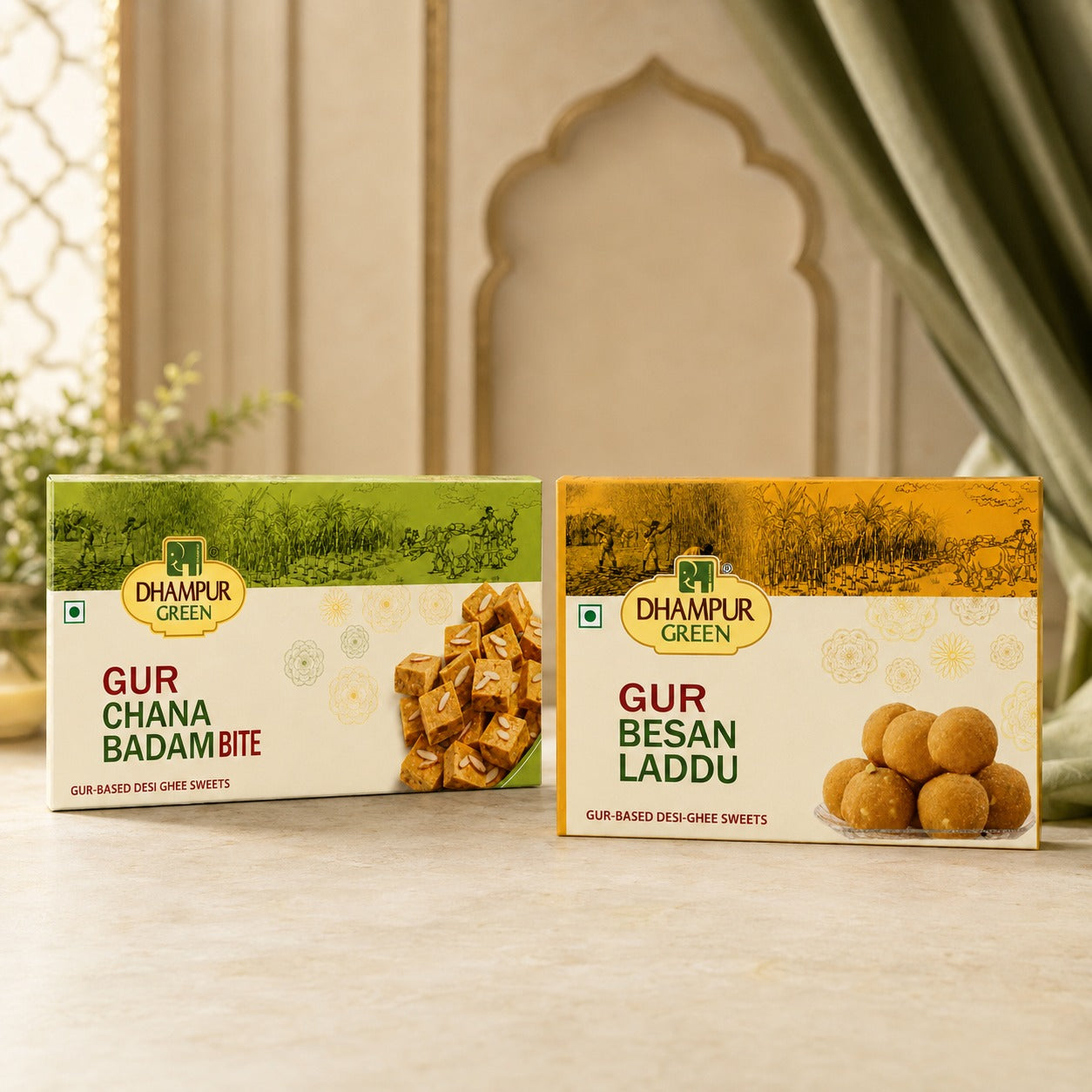 Two boxes of DHAMPUR GREEN desi ghee sweets displayed on a marble surface. The left box is for 'Gur Chana Badam Bite' with green packaging and an image of wrapped sweets.