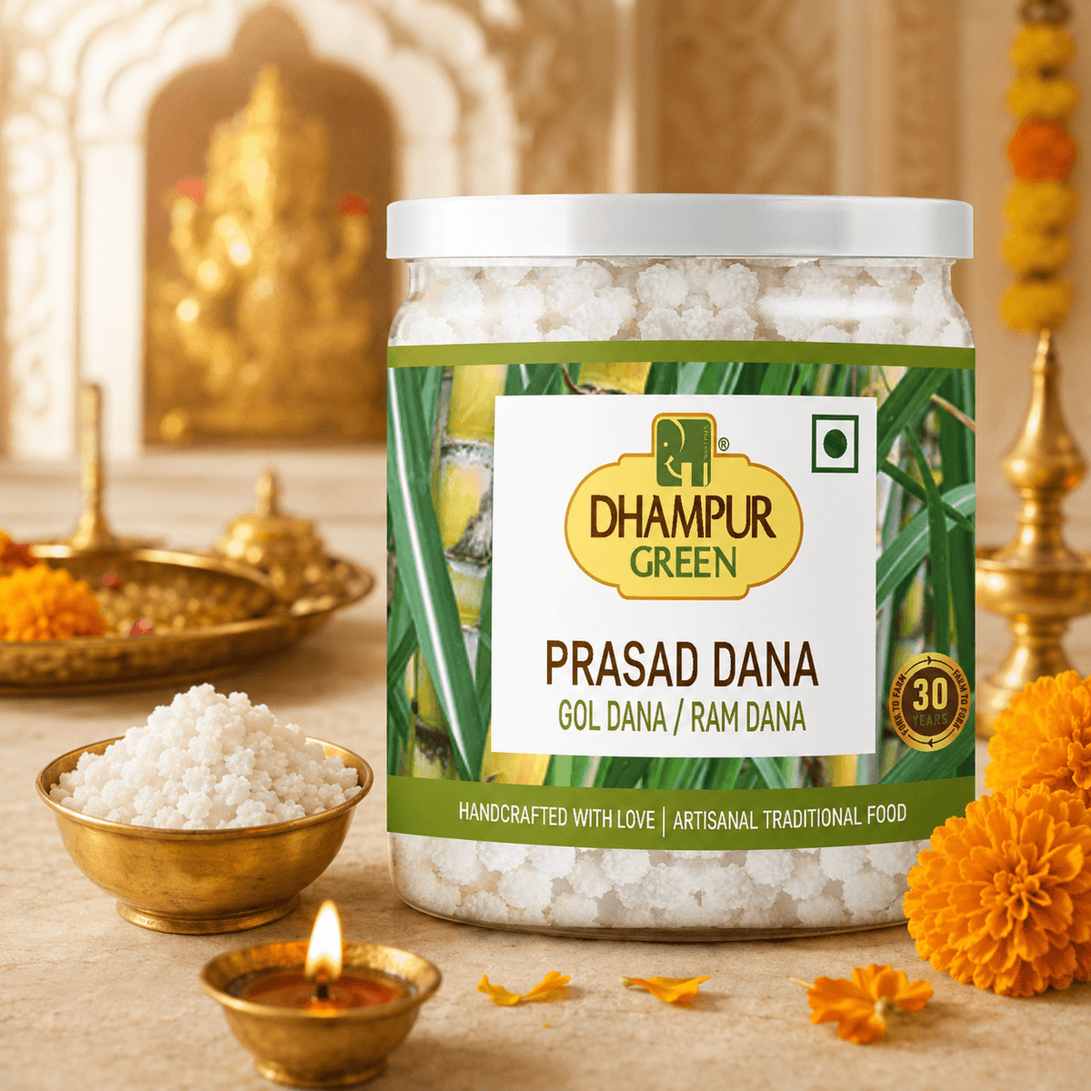 A jar of Dhampur Green Prasadana (Gol Dana / Ram Dana) filled with white crystalline salt, displayed on a beige surface with traditional Indian elements including a brass diya, marigold flowers, and a brass bowl of salt. The background features a softly blurred golden temple arch.